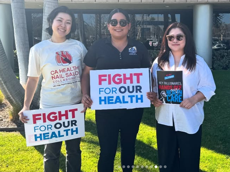 Jessie Lopez holding a "fight for our health" sign with two other protestors.