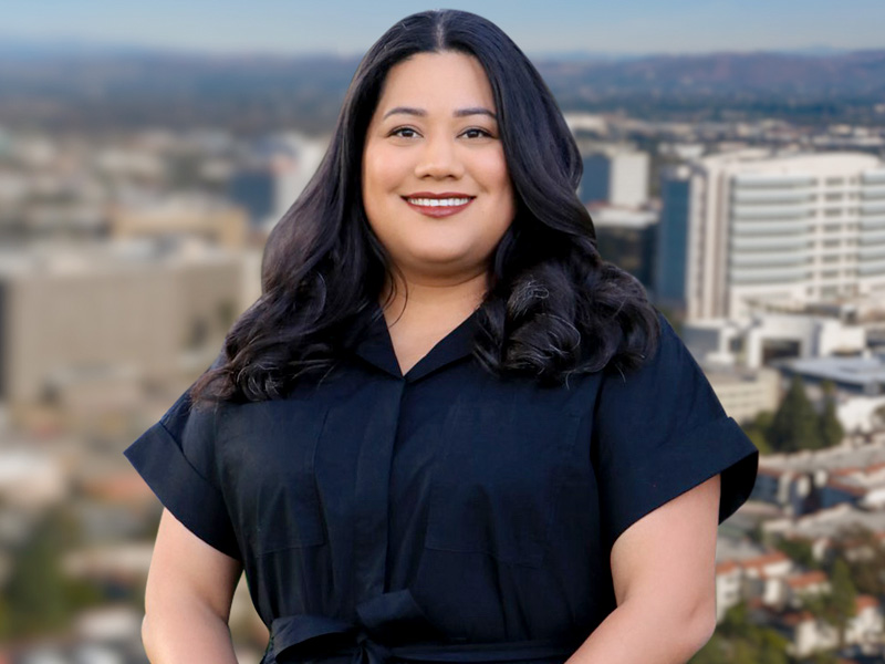 Jessie Lopez smiling in front of a city background showing California's 68th Assembly District.