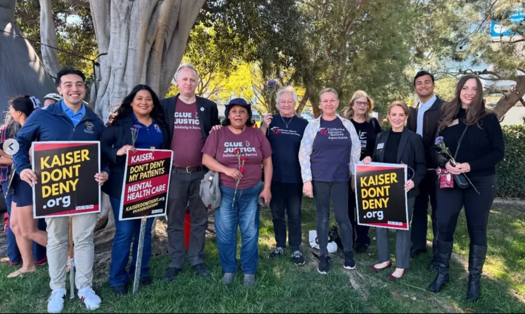 Councilwoman Jessie Lopez standing with a group of striking Kaiser healthcare workers, some holding signs.