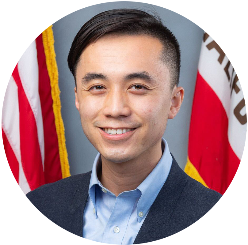 Portrait of Assemblymember Alex Lee in front of an American and California flag.