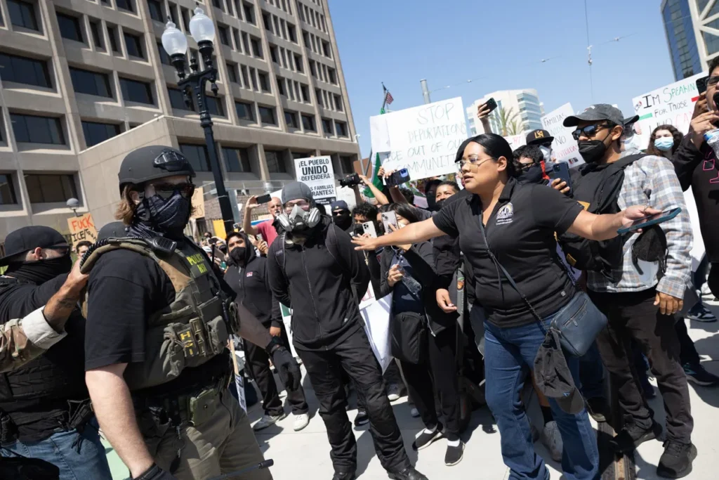 Councilwoman Jessie Lopez shields protestors during a Downtown Santa Ana protest.