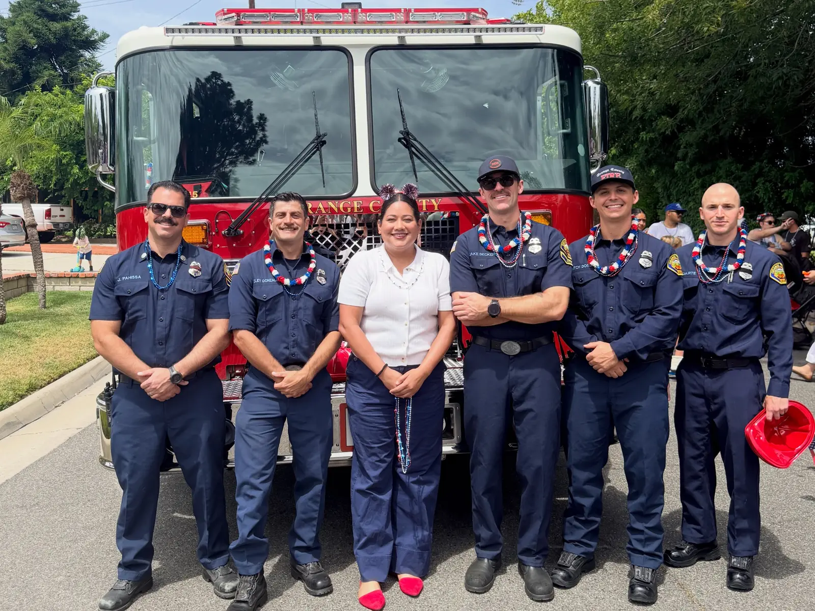 Jessie Lopez standing with firefighters in front of a fire truck.