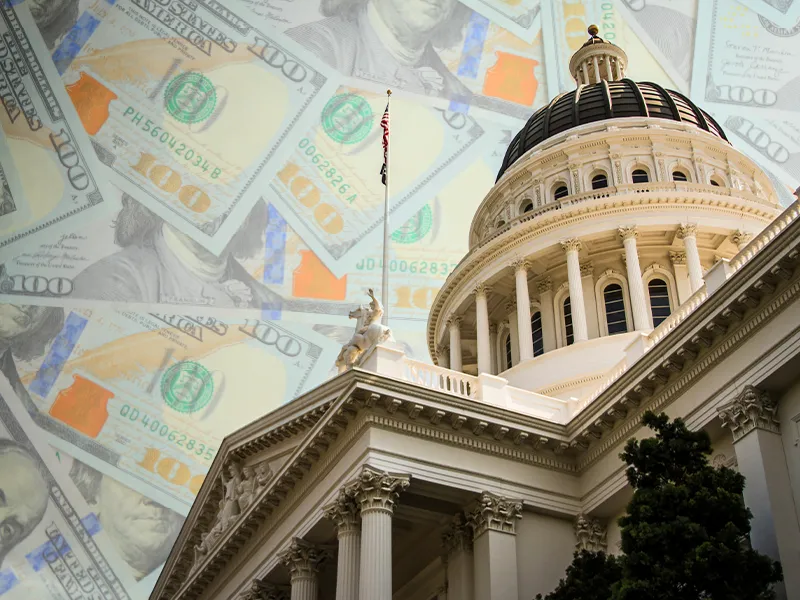Looking up at the California Capitol building with money in the sky.